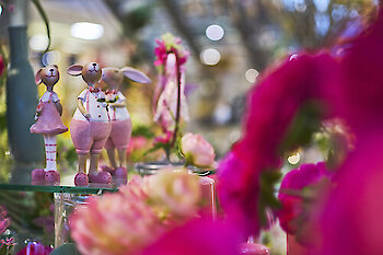 Frühlingshafte Hasenfiguren in Rosa mit floraler Deko und bunten Blumen bei JOSKA.